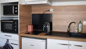 A compact kitchen with a microwave, toaster, and a small refrigerator.