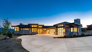 A modern two-story house with a stone facade, large windows, and a well-lit driveway. - Red Ledges luxury escape, golf, min 90 day stay (Heber City)