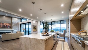 A modern kitchen with a large island, built-in appliances, and a view of the city. - Red Ledges luxury escape, golf, min 90 day stay (Heber City)