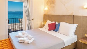 A hotel room with a bed, a view of the sea, and a balcony. - I Tre Re (Bardolino)