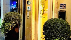 The exterior of a hotel named "ITRE RE ROOMS" with a crown logo, a reception area, and two large potted plants at the entrance. - I Tre Re (Bardolino)