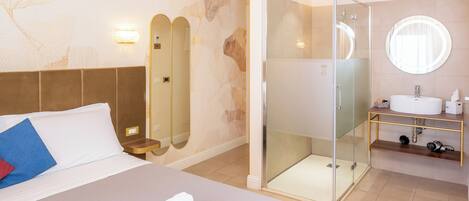 A hotel room with a bed, a shower, and a bathroom with a sink and mirror.