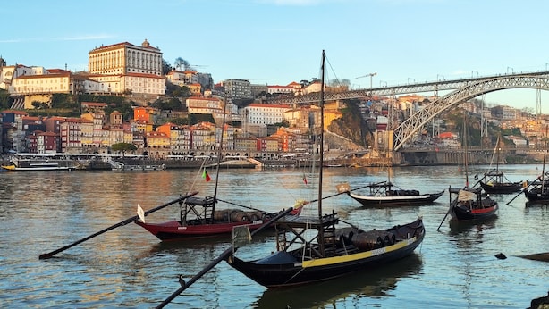 A harbor with boats docked, a bridge, and buildings in the background. - Fervença Apartments - Corgo (Vila Nova de Gaia)