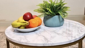 A round marble table with a blue plant and a bowl of fruit. - Charming 1-bed, Sleeps 2, Parking (Leeds)