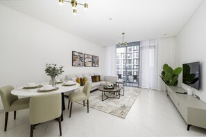 Un soggiorno moderno con zona pranzo, divano, tavolino e televisione.
