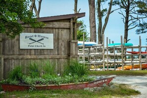 A wooden structure labeled 'Boat House Point Check-In' with a boat docked in front. - Bayside Resort:  Beautiful 5 Bedroom House with 3. (Selbyville)