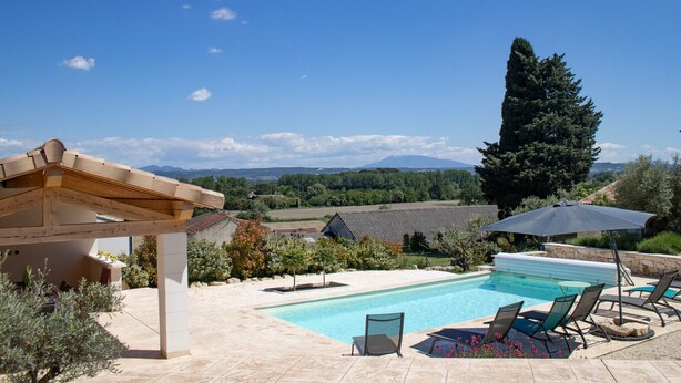 A swimming pool with lounge chairs and an umbrella, surrounded by a garden and a view of distant mountains. - Villa in Provence with pool, garden and Ventoux view – Colonzelle (Colonzelle)