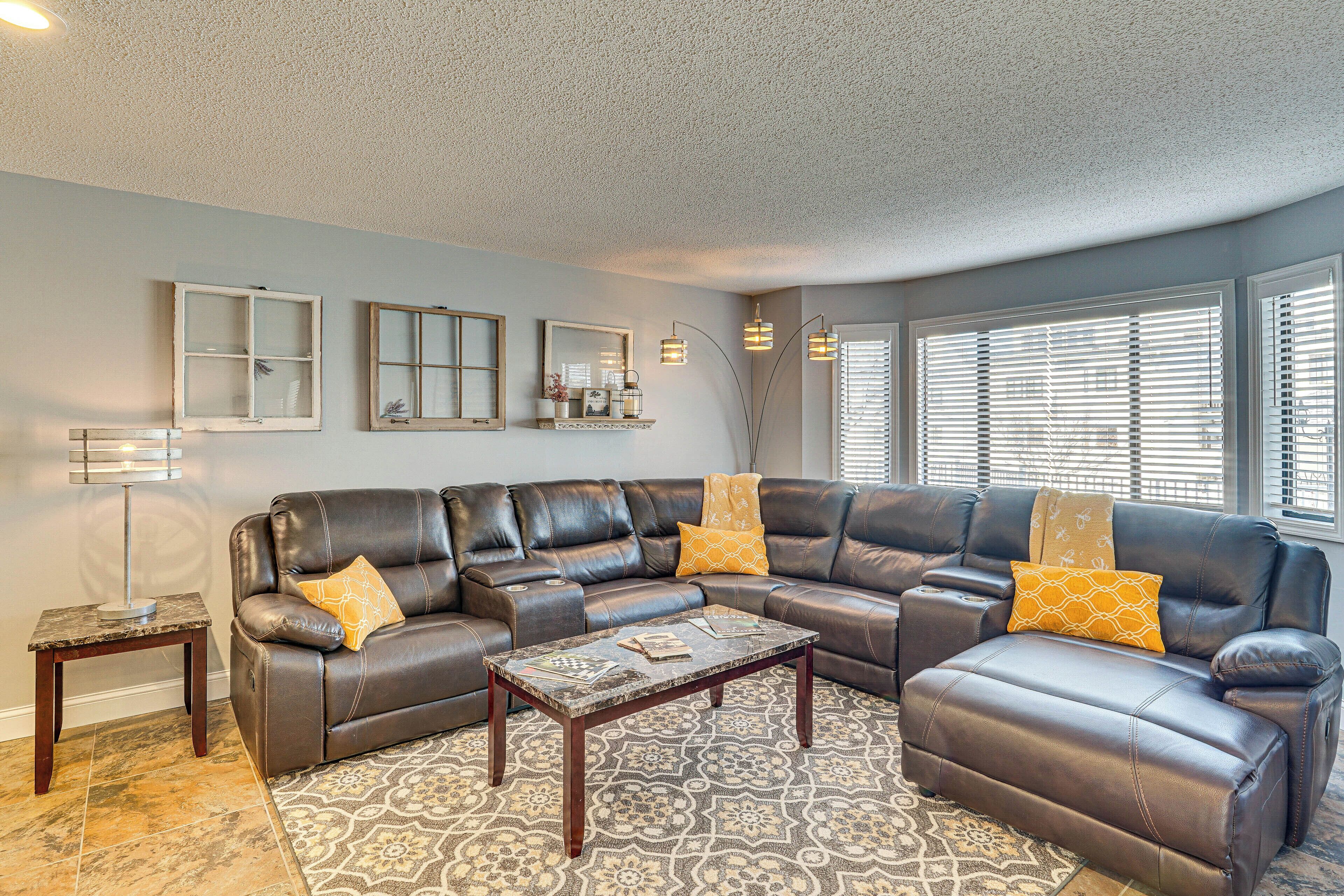 A living room with a sectional sofa, a coffee table, a patterned rug, and a floor lamp.