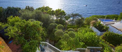 A coastal property with a staircase leading to a terrace overlooking the sea.