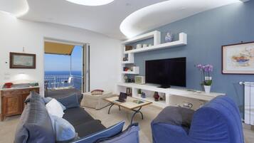 Un soggiorno moderno con balcone, televisione a schermo piatto e diversi oggetti decorativi.