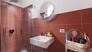Un bagno con doccia, lavandino e specchio.
