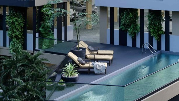 A rooftop pool area with lounge chairs and potted plants.