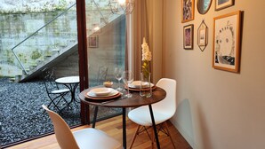 Ein Essbereich mit Tisch für zwei Personen, einer Blumenvase und einem Bild an der Wand.