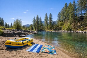 A riverbank with a raft and a beach towel.