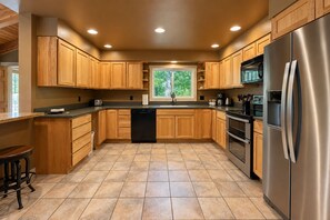A modern kitchen with wooden cabinets, a stainless steel refrigerator, and a dishwasher. - Riverside Cabin-River, Hot Tub, WIFI, Dogs OK (Leavenworth)