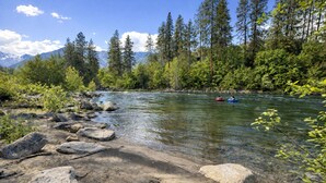 A river with clear water, surrounded by rocks and greenery.