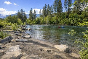 A river with clear water, surrounded by rocks and greenery.