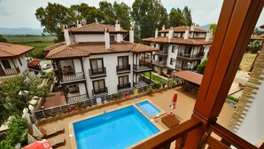 Un hotel con una gran piscina, varios balcones y vistas al paisaje circundante.
