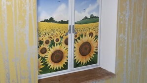 A room with a window featuring a sunflower mural. - Rustic cottage in the heart of the Bastides, Lot-et-Garonne.  Perfect for 2! (Montauriol)