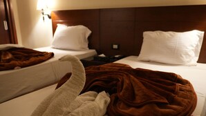 A hotel room with two beds, each with white linens and brown blankets. - Montana Hotel (Cairo)