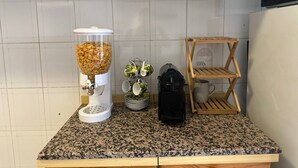 A kitchen counter with a coffee maker, a food processor, and a wooden rack. - Room in B&B - Comfortable Room With Spacious Kitchen - Suite Colosseo (Rome)