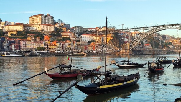 A harbor with boats docked, a bridge, and buildings in the background. - Fervença Apartments - Sabor (Vila Nova de Gaia)