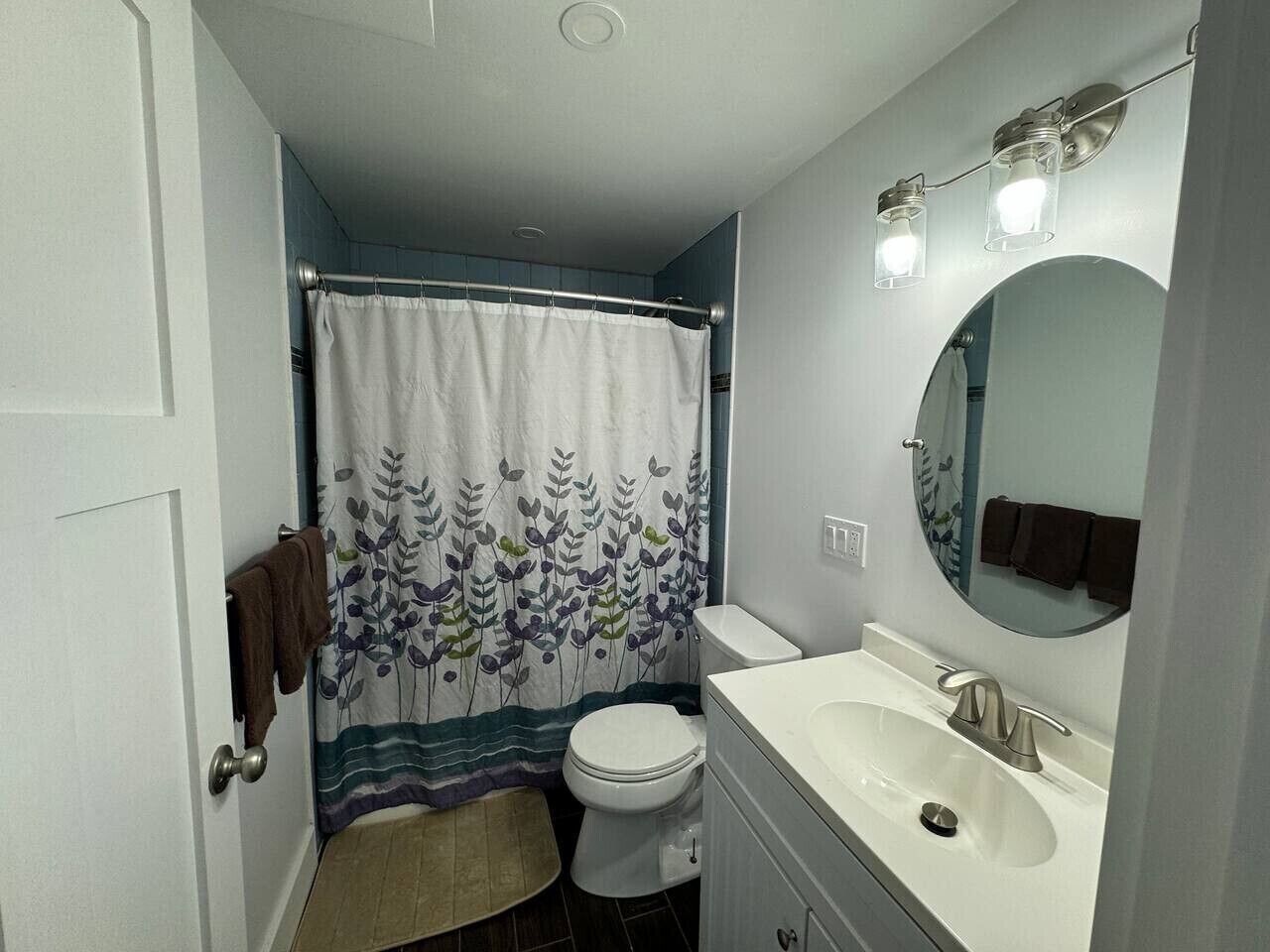Ein kleines Badezimmer mit Toilette, Waschbecken und Duschvorhang.