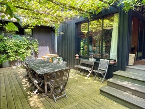 Enjoy a peaceful outdoor retreat with a patio featuring a table, chairs, and a bench.
