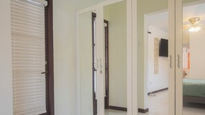 A bedroom with a bed, a television, and a door with a mirror.