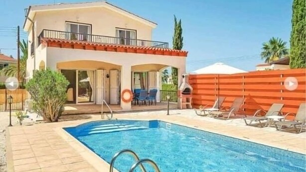 Et toetagers hus med swimmingpool, udendørs møbler og en indhegnet patio.