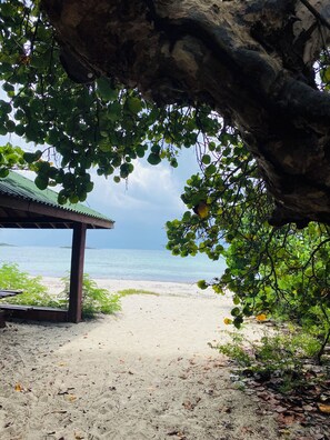 A beach scene with a wooden structure and a view of the ocean. - Cool Vibe Island Home with a designer garden & new pool. A/C in bedrooms! (Vieques)