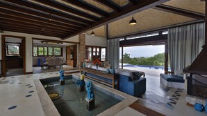 A spacious indoor area with a pool, seating, and a view of the outdoors. - Cap Ferrat Boutique Hotel (Búzios)