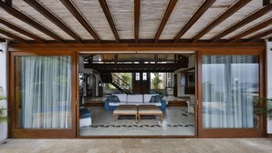A spacious living area with a sofa set, a coffee table, and a patterned rug. - Cap Ferrat Boutique Hotel (Búzios)
