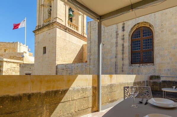 A stone building with a bell tower and a flag.