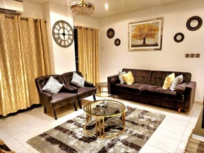 Relax in style with a comfortable sofa, coffee table, and artwork, set against a stylish backdrop.