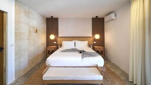 Suite – junior, hageutsikt | Senger med overmadrass, minibar, safe på rommet og blendingsgardiner