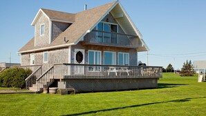A two-story house with a balcony, a chimney, and a deck. - Relaxing 3 bedroom cottage located in beautiful Prince Edward Island, Canada (Kensington)