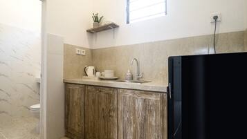 Una cocina compacta con un armario de madera, un lavamanos y una encimera.
