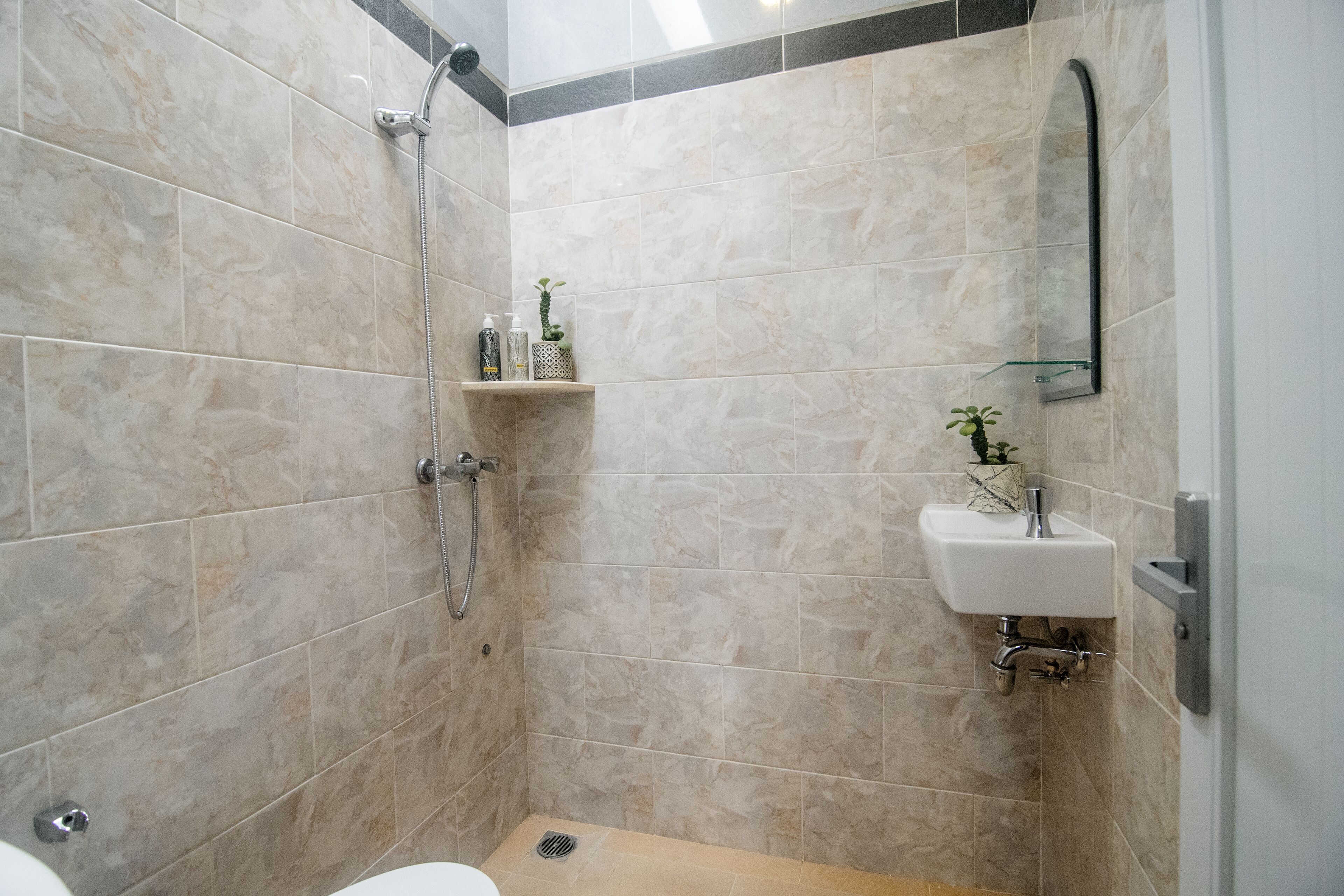 A modern bathroom with a shower, toilet, and sink.