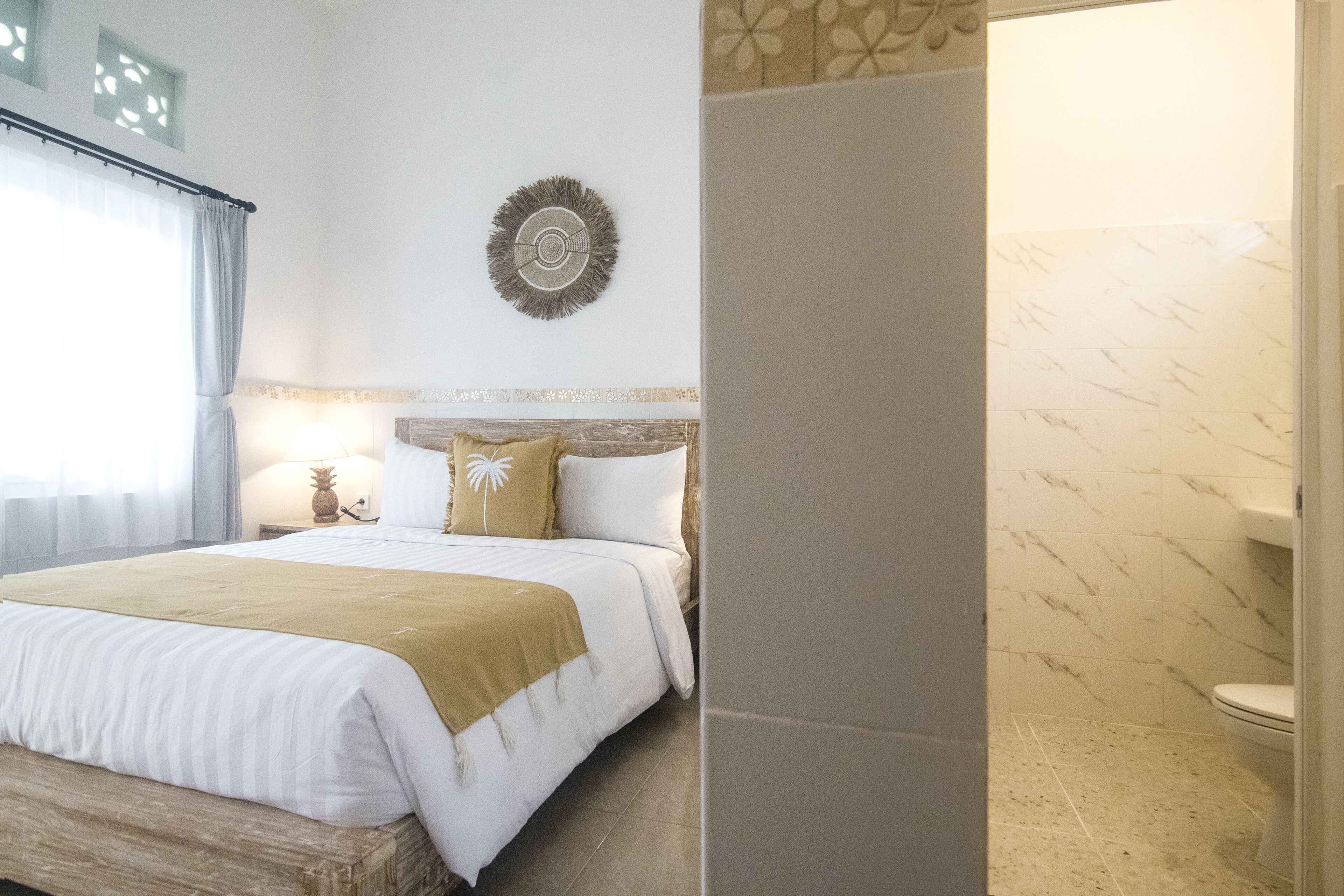Une chambre d’hôtel comprenant un lit, une table de chevet, un élément de décoration murale et une salle de bain avec des toilettes et une douche.