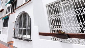 A white building with arched windows and a balcony.