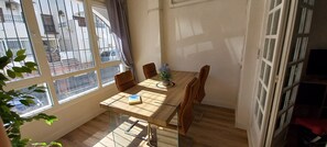 Een eethoek met een tafel, stoelen en een plant.