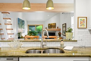 A modern kitchen with a built-in oven, a stainless steel sink, and a wooden countertop.