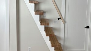 A staircase with wooden steps and white walls, leading to a door. - The Buddha House - Luxurious North Boulder Retreat (Boulder)