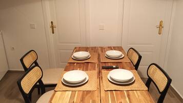 A dining table with four chairs, a remote control, and placemats.