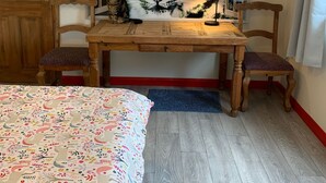 A bedroom with a large tiger mural, wooden furniture, and a bed with a colorful blanket. - Cozy Coastal Apartment in Kilgetty With Views (Kilgetty)