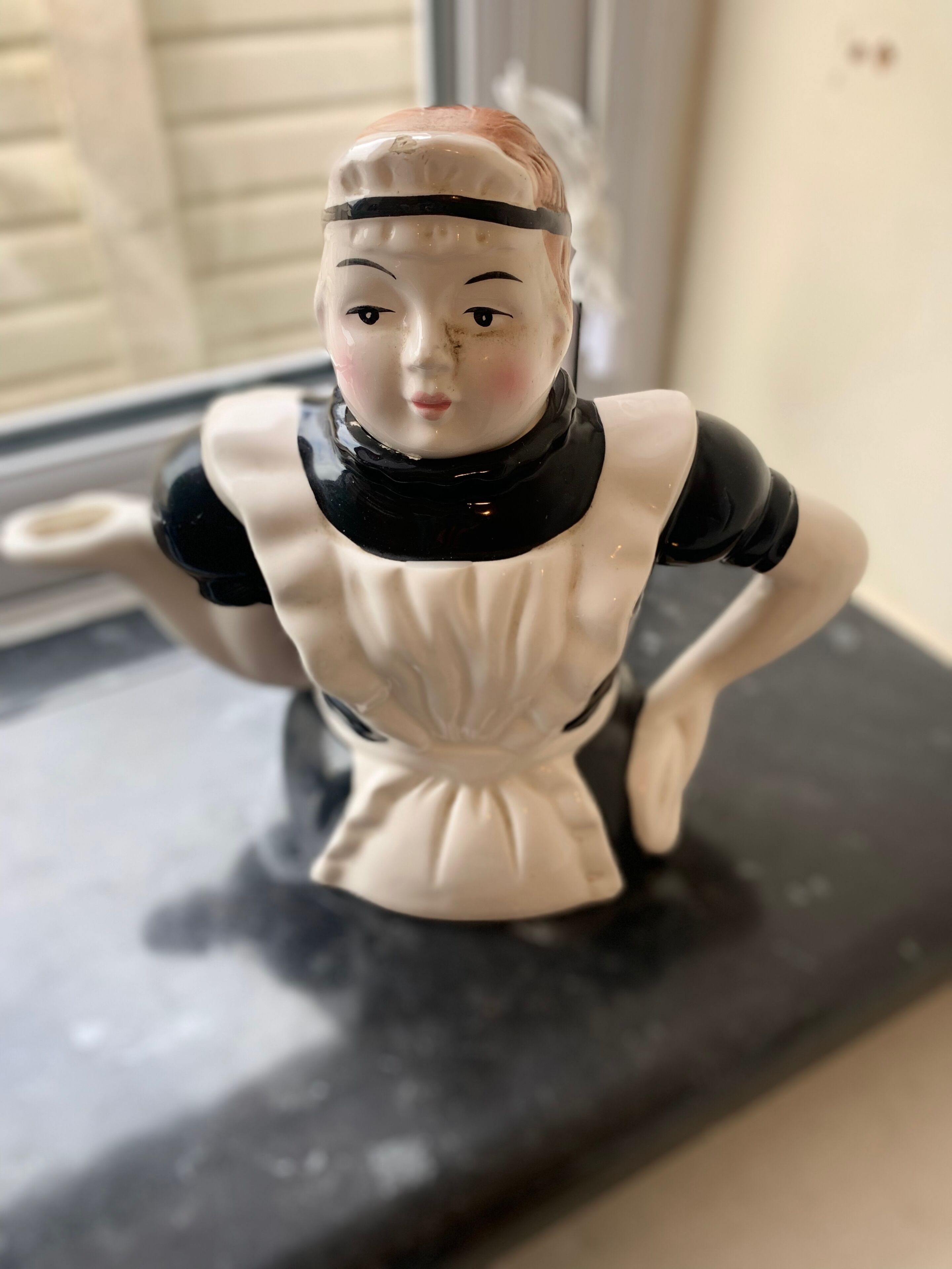 A ceramic figurine on a black surface.