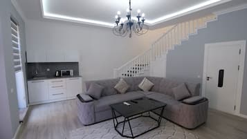 Habitación cuádruple familiar, vista a la alberca | Área de sala de estar | Smart TV de 1000 cm con canales digitales