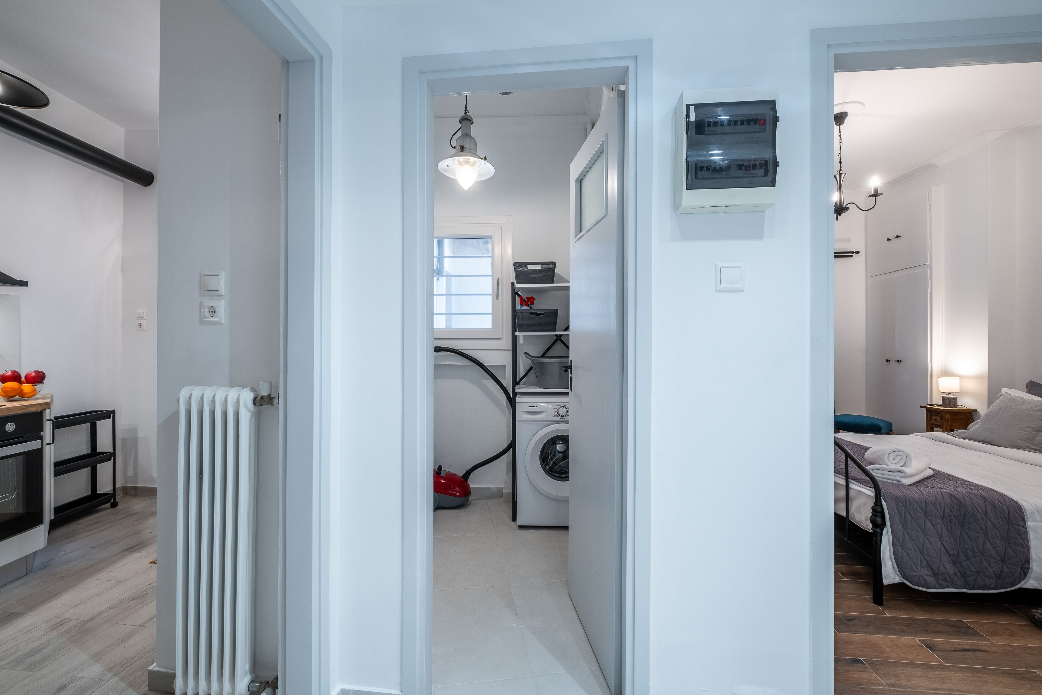 Un espace de vie compact comprenant une cuisine, un coin buanderie et une chambre.