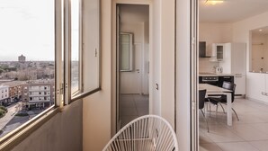 A modern apartment with a balcony, a dining area, and a kitchen. - Ravenna Sky View Apartment (Ravenna)